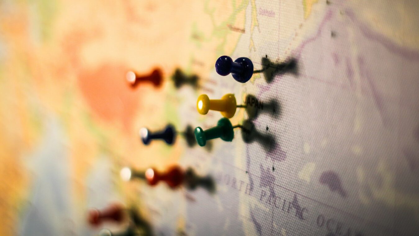 selective focus photography of push pin in map